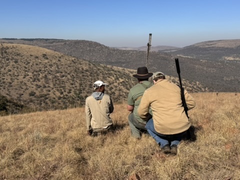 A professional hunter and guests pausing on a ridge