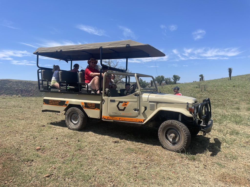 Guests riding in a Cowley Safaris open safari vehicle