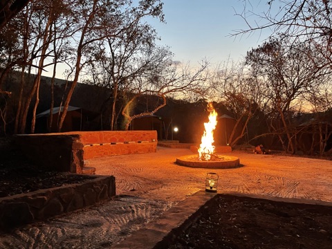 Campfire burning in the Tented Bush Camp boma at dusk